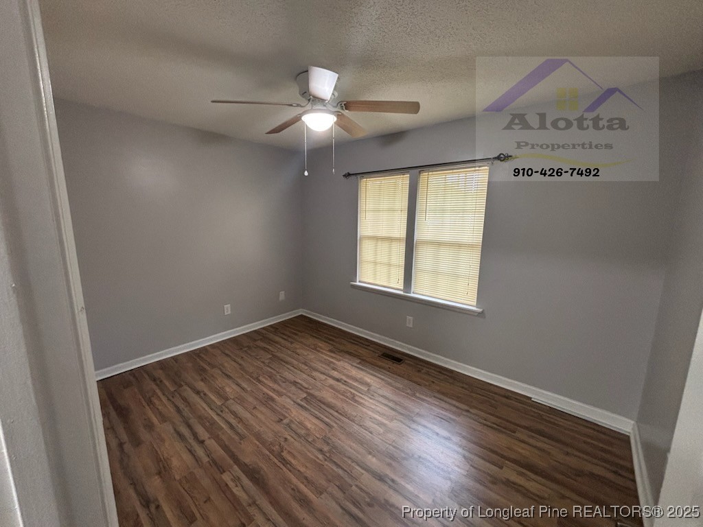 1810 Murchison Road Fayetteville, NC 28301 - Photo 7 of 10 an empty room with wooden floor fan and windows