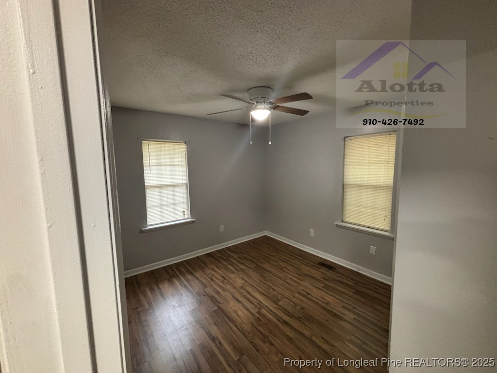 1810 Murchison Road Fayetteville, NC 28301 - Photo 8 of 10 an empty room with wooden floor fan and windows