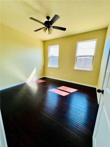 a view of empty room with wooden floor