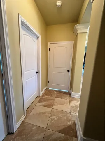 a view of a hallway with wooden floor and a door