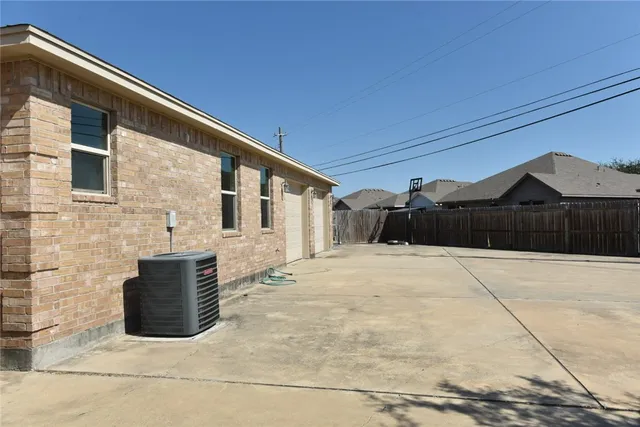 a view of backyard and wooden fence