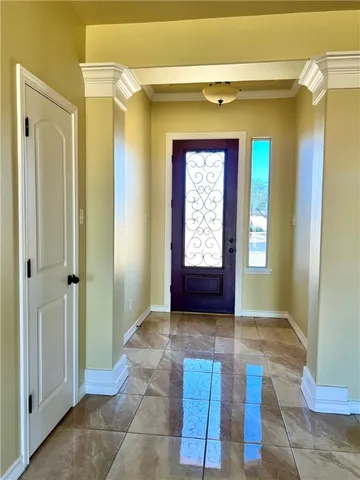 a view of hallway with chandelier and a glass door