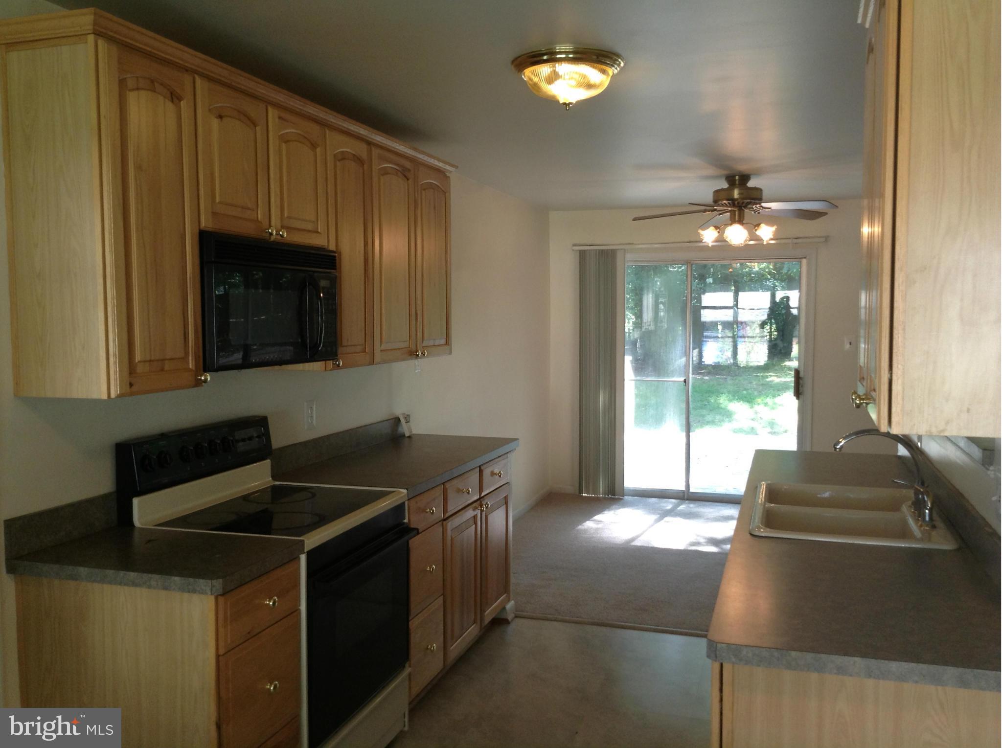 16308 Dahl Road Laurel, MD 20707 - Photo 6 of 9 a kitchen with granite countertop a sink and a stove top oven