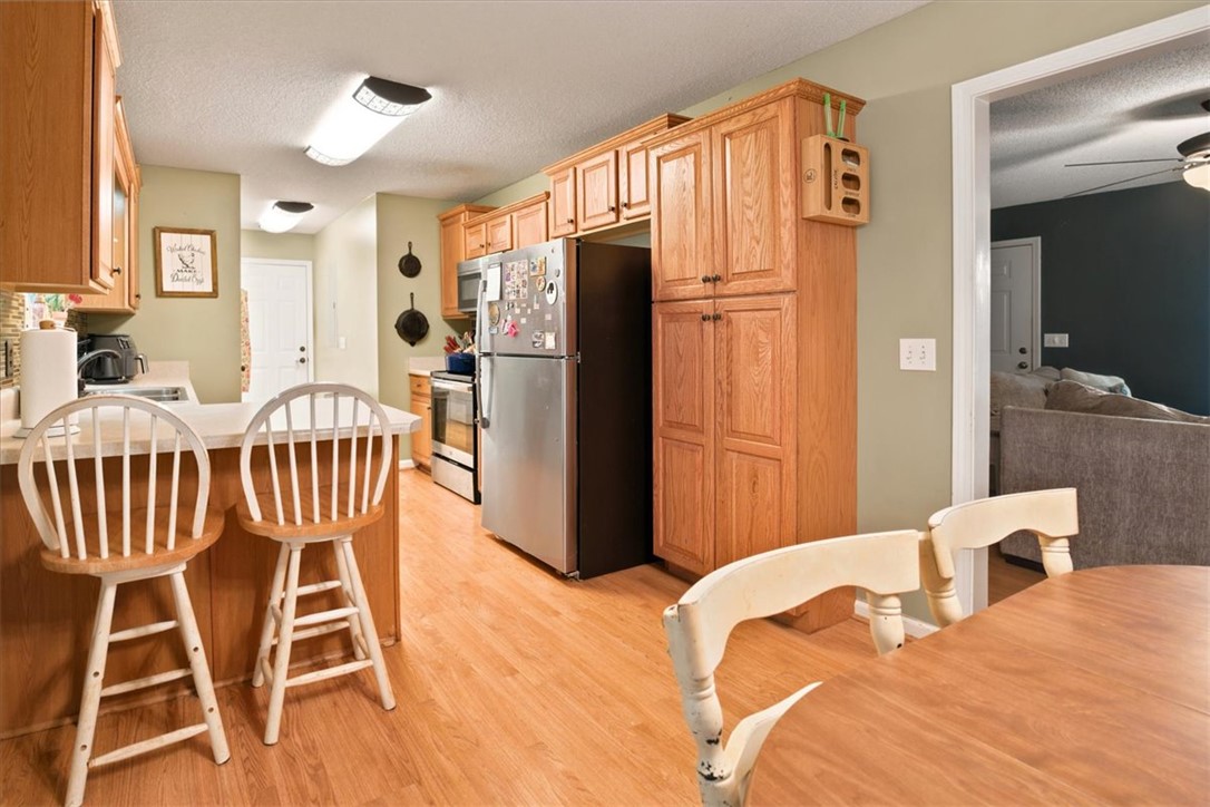 520 Sharon Lane Seneca, SC 29678 - Photo 14 of 48 Functional kitchen with warm wood cabinetry, a breakfast bar, and durable flooring offers easy meal prep and casual dining.