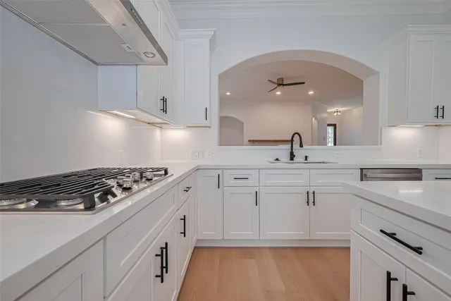 a kitchen with white cabinets and appliances