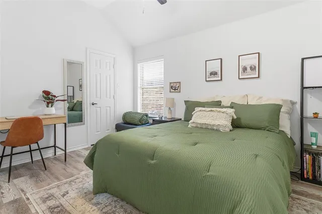 a spacious bedroom with a bed a couch and a potted plant