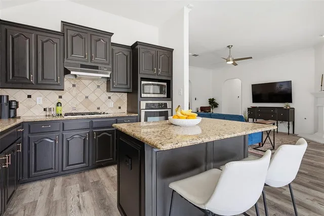 a kitchen with stainless steel appliances granite countertop a sink stove and refrigerator