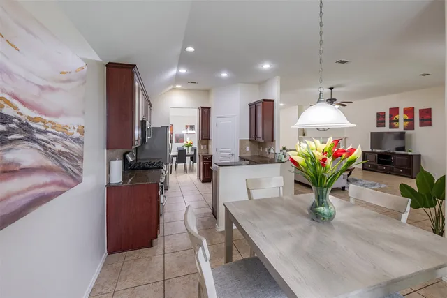 a kitchen with granite countertop stainless steel appliances a refrigerator a stove top oven a sink and cabinets