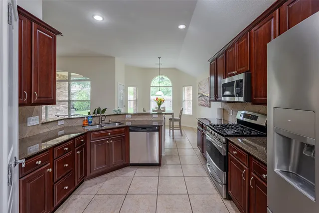 a dining room with kitchen island furniture a chandelier and kitchen view