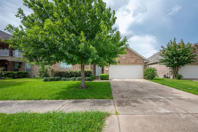 a front view of a house with a yard and a garage