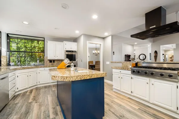 a kitchen with stainless steel appliances granite countertop a sink refrigerator and cabinets