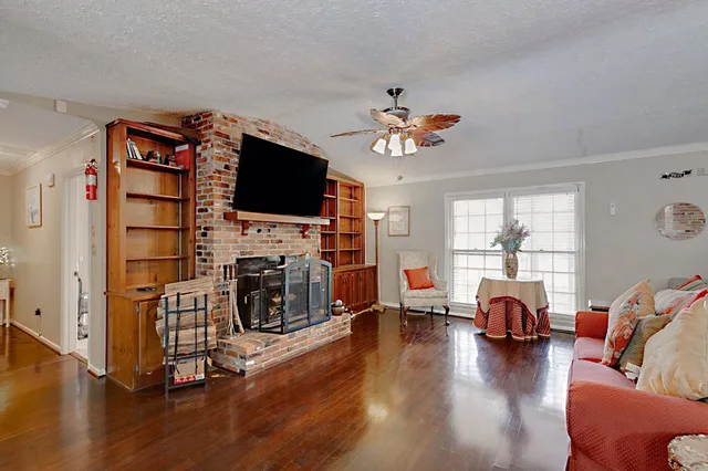 a living room with furniture a fireplace and a flat screen tv