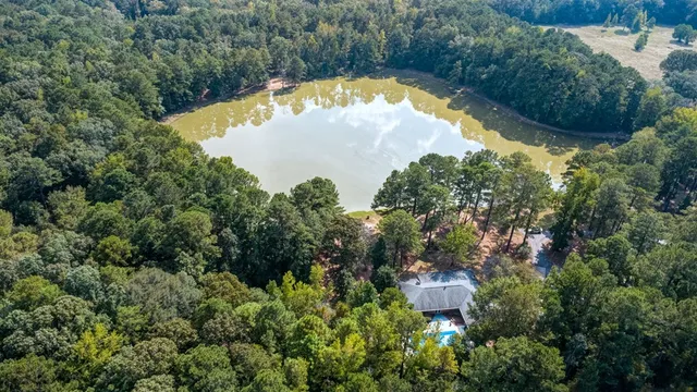 an aerial view of lake residential house with outdoor space and trees all around