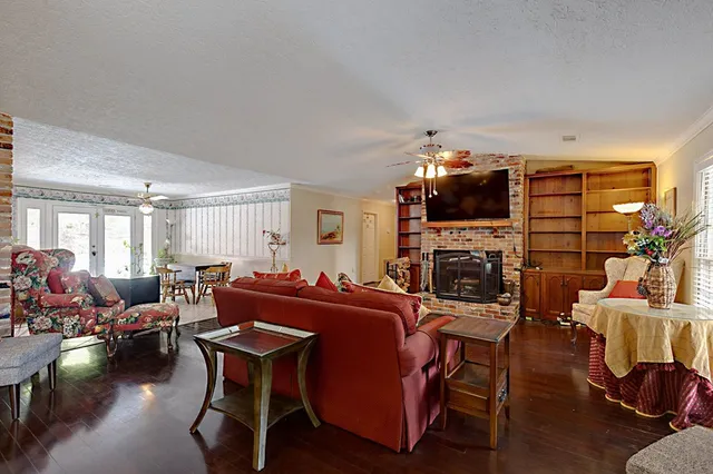 a living room with furniture a fireplace and a flat screen tv