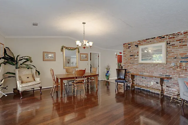 a view of a dining room with furniture chandelier and wooden floor
