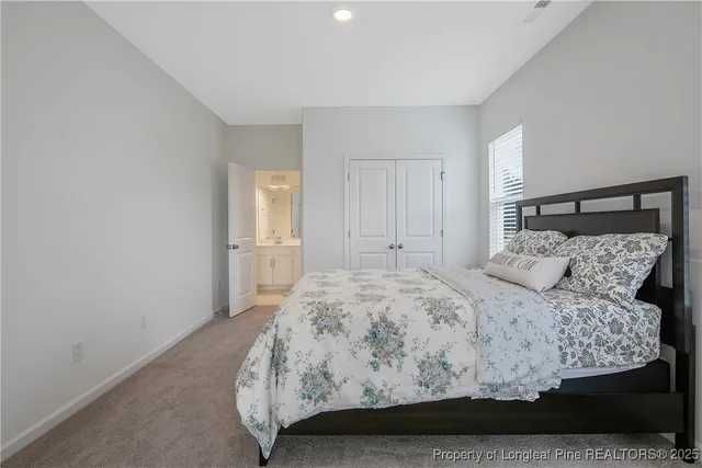 a bedroom with a large bed and wooden floor