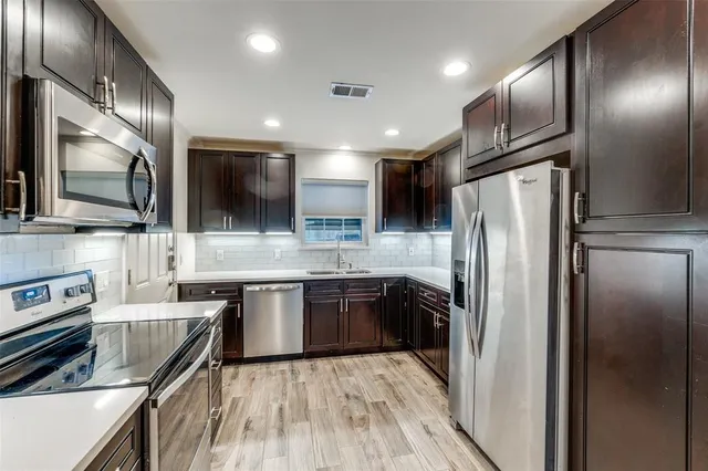 a kitchen with stainless steel appliances granite countertop a refrigerator and a stove top oven