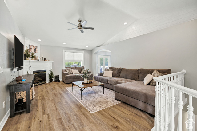 2280 South 450 West Perry, UT 84302 - Photo 6 of 38 Living room featuring light wood-style flooring, recessed lighting, a glass covered fireplace, lofted ceiling, and arched walkways