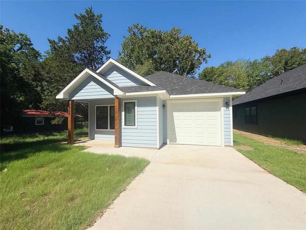 Single story home featuring driveway, a front lawn, a garage, and roof with shingles