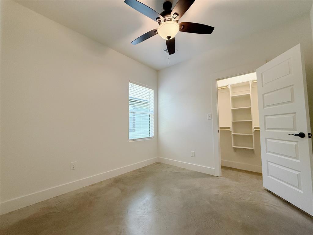 1905 South Lamar Denison, TX 75021 - Photo 22 of 27 Unfurnished bedroom featuring finished concrete flooring, a spacious closet, and ceiling fan
