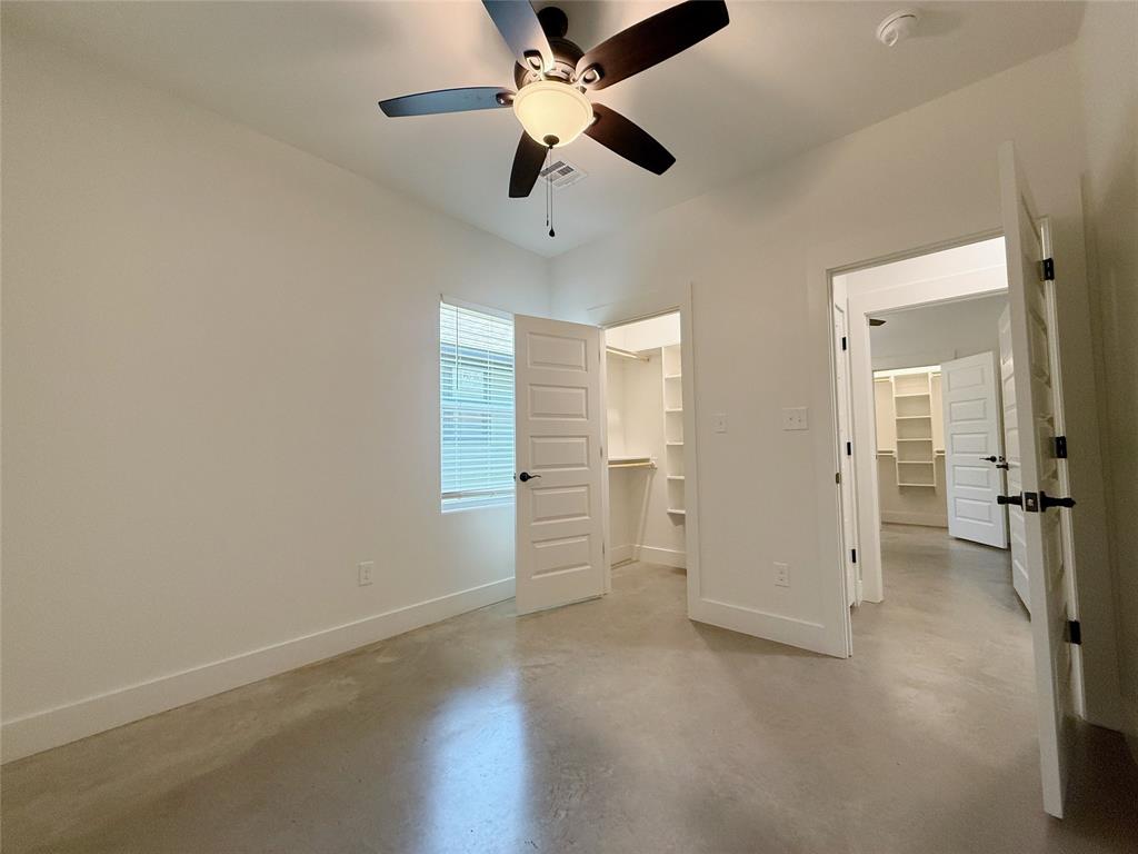 1905 South Lamar Denison, TX 75021 - Photo 25 of 27 Unfurnished bedroom featuring a spacious closet, concrete floors, and ceiling fan