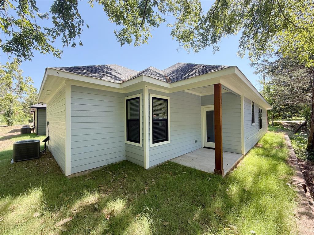 1905 South Lamar Denison, TX 75021 - Photo 27 of 27 View of home's exterior with a patio area, a lawn, and roof with shingles