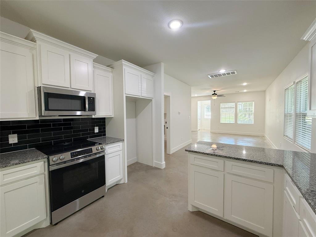 1905 South Lamar Denison, TX 75021 - Photo 10 of 27 Kitchen featuring stainless steel appliances, finished concrete floors, white cabinetry, decorative backsplash, and recessed lighting