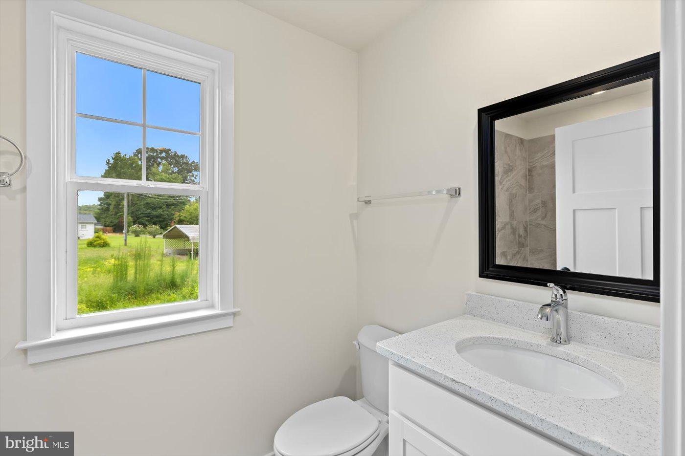 62 Rose Way Colonial Beach, VA 22443 - Photo 32 of 43 a bathroom with a toilet sink vanity and mirror