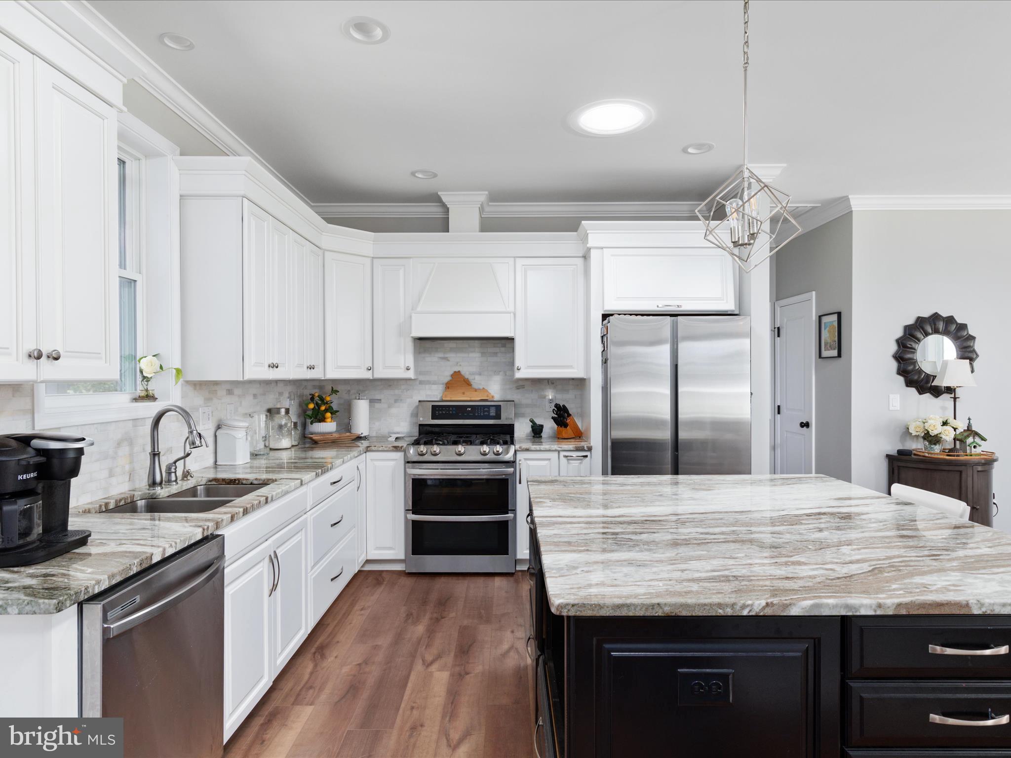 1857 Polk Road Edinburg, VA 22824 - Photo 11 of 55 a kitchen with kitchen island granite countertop a sink stainless steel appliances and white cabinets