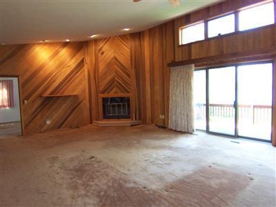 Undisclosed Address Centerville, MA 02632 - Photo 10 of 21 a view of an empty room with a fireplace and a window