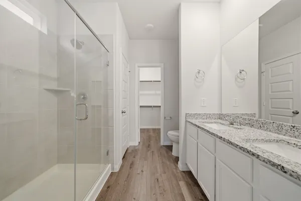 a bathroom with a granite countertop sink a toilet and shower