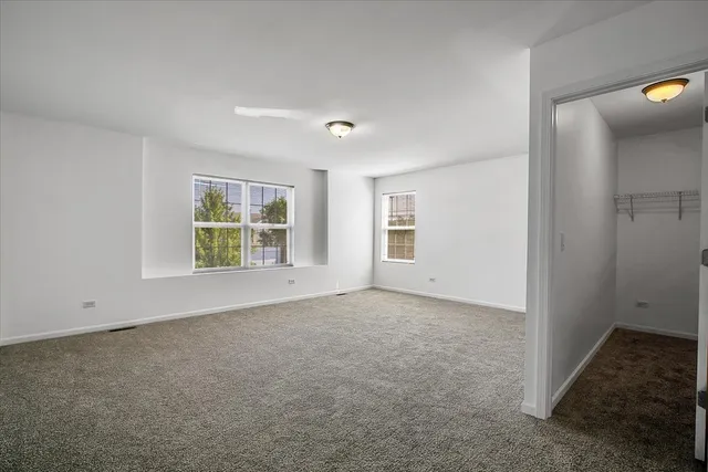 an empty room with windows and closet