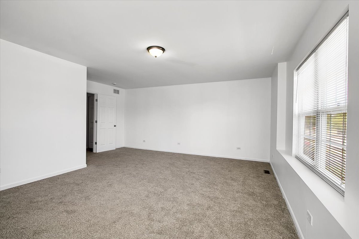 4932 Montauk Drive, Unit 4932 Plainfield, IL 60586 - Photo 15 of 23 an empty room with a empty space and windows