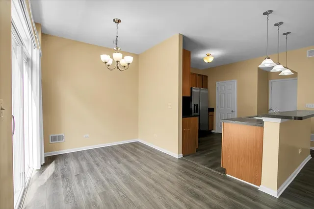 a view of a kitchen with refrigerator and wooden floor