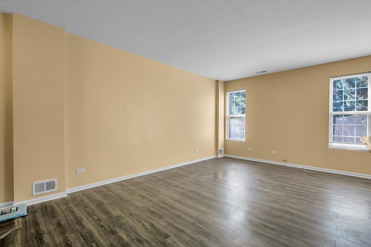 4932 Montauk Drive, Unit 4932 Plainfield, IL 60586 - Photo 8 of 23 a view of an empty room with wooden floor and a window