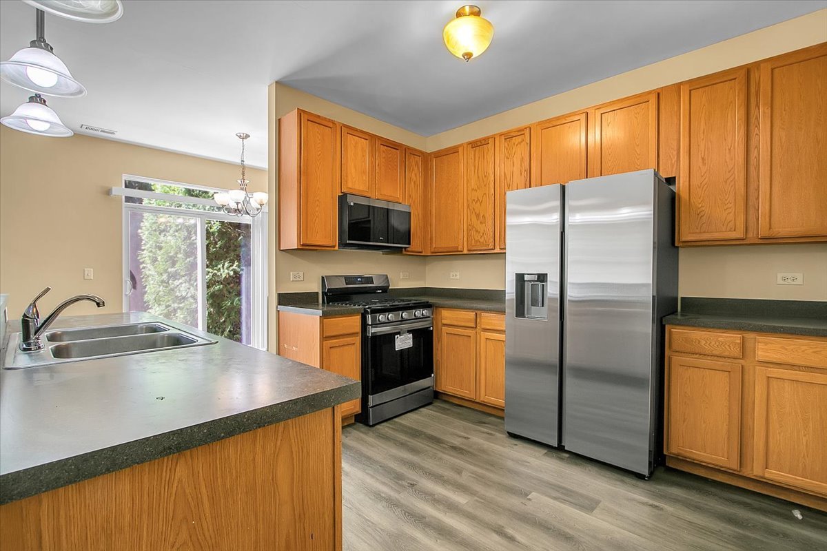4932 Montauk Drive, Unit 4932 Plainfield, IL 60586 - Photo 9 of 23 a kitchen with stainless steel appliances a refrigerator sink and microwave