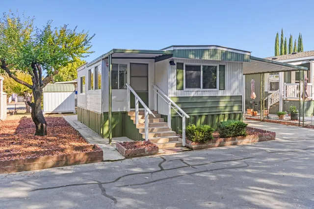 a front view of a house with a yard and potted plants