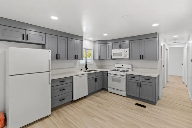 a kitchen with a refrigerator stove and wooden cabinets