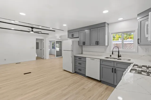 a kitchen with stainless steel appliances granite countertop a sink stove and refrigerator