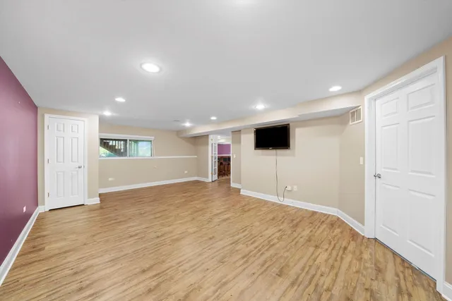 a view of empty room with wooden floor and windows