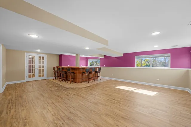 a view of an empty room with wooden floor and windows