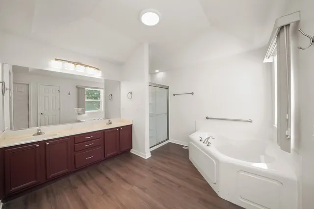 a bathroom with a tub sink and mirror