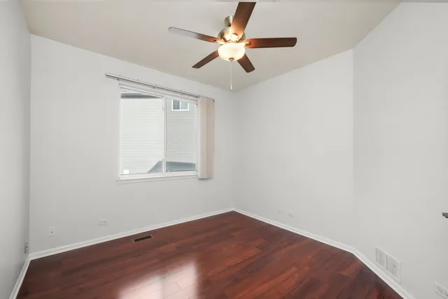 an empty room with a window and a ceiling fan