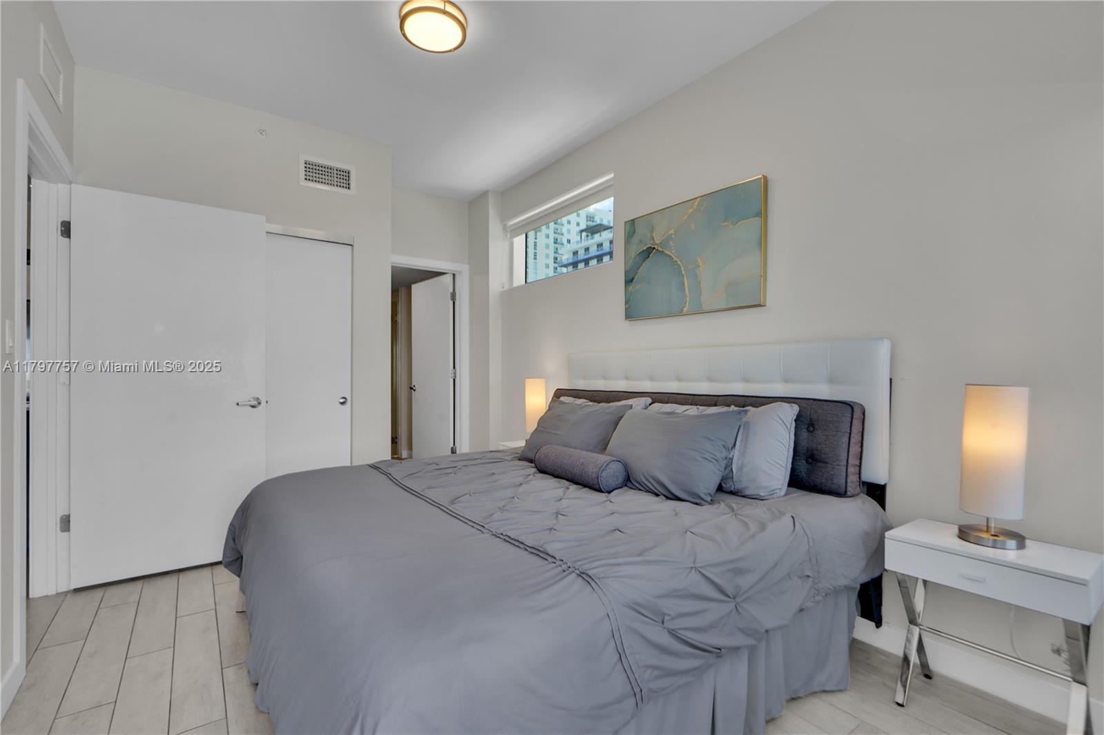 321 Northeast 26th Street, Unit 806 Miami, FL 33137 - Photo 12 of 43 a bedroom with a bed and a lamp on dresser