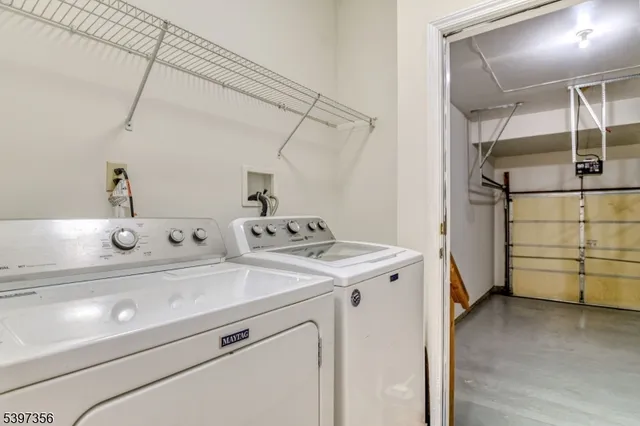 a view of a hallway to a livingroom with wooden floor a fireplace and entryway