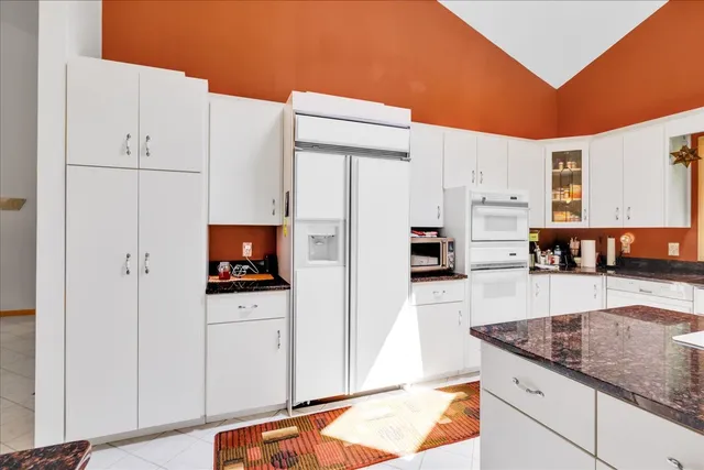 a kitchen with white cabinets and appliances