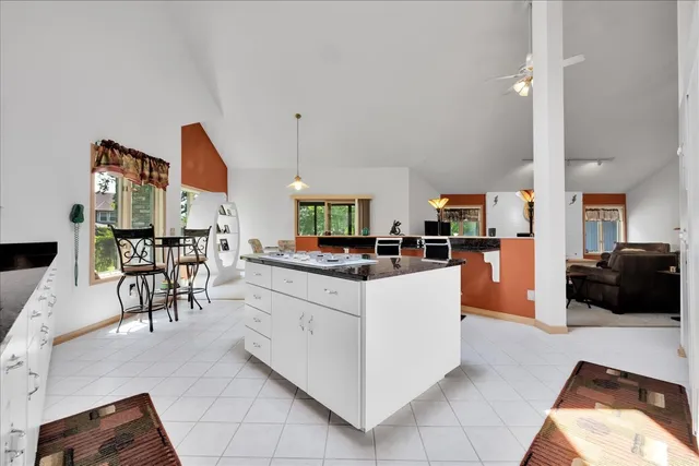 a kitchen with stainless steel appliances kitchen island granite countertop a table and chairs in it