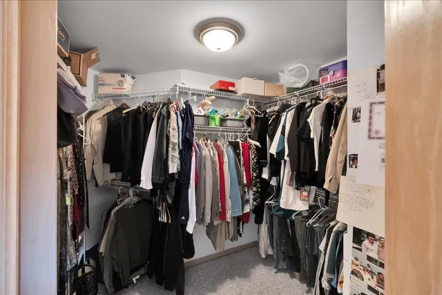 a view of walk in closet with clothes