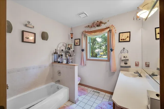 a bathroom with a tub sink and mirror