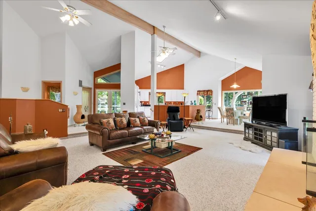 a living room with furniture a flat screen tv and a large window